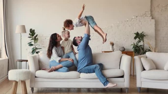 夫妇和两个孩子在舒适的客厅里玩耍