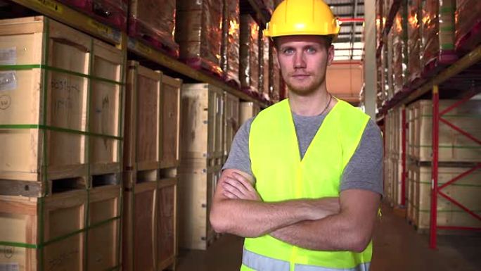 白人工人穿着反光衬衫和头盔，站着看着相机，他努力检查仓库中的货物，用于工业用途，陆运和空运货运