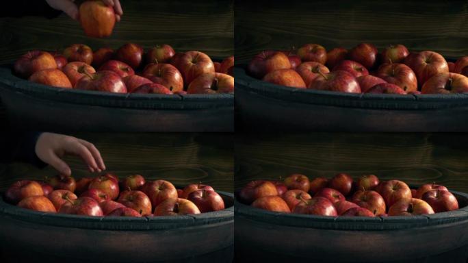男子从桶中捡起苹果