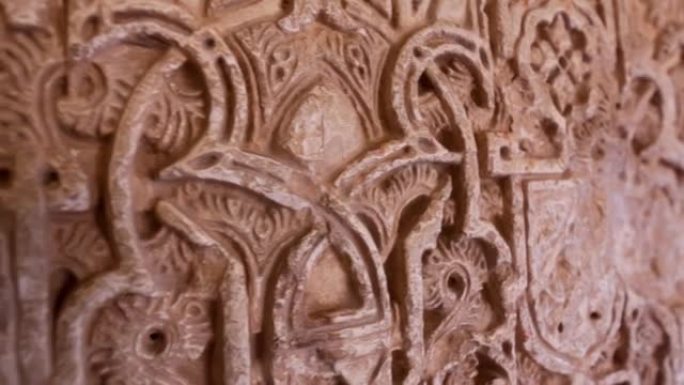 西班牙格拉纳达阿尔罕布拉宫建筑墙细节的万向节镜头。摄像机沿着装饰有摩尔装饰的墙壁移动