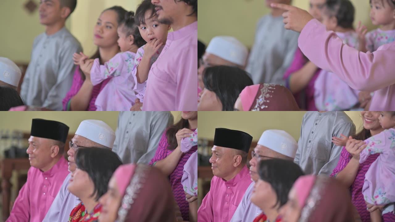 马来西亚马来人一家人在家里挥舞着庆祝hari raya的相机拍照