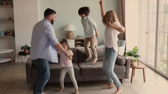 妈妈爸爸和女儿跳舞，而儿子则跳到沙发上