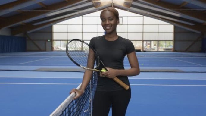 站在网球场上的非洲年轻女子的肖像