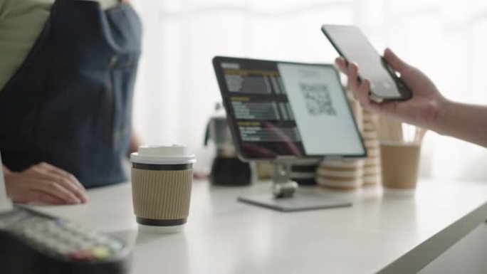 客户通过智能手机进行非接触式支付，在咖啡店进行二维码支付