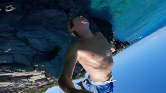 POV极端年轻人在悬崖跳进热带蓝色海洋时做后空翻