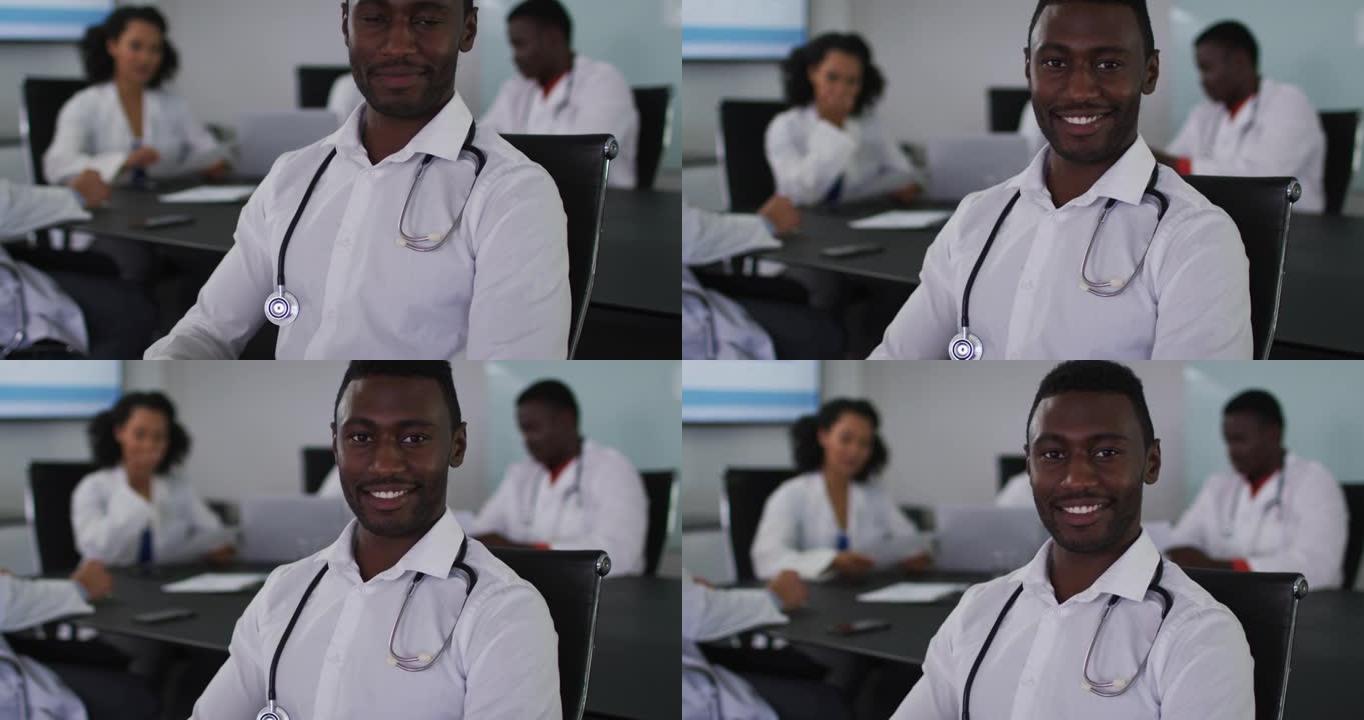 坐在会议室里的非洲裔美国男医生的肖像，对着镜头微笑