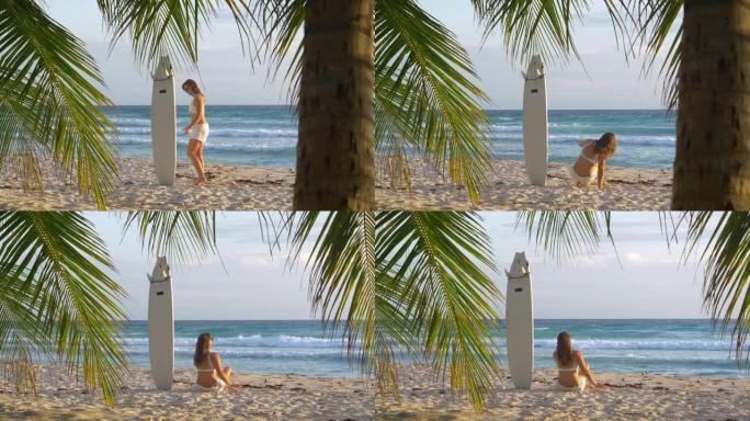 慢动作女子将冲浪板粘在沙滩上坐下观察日出