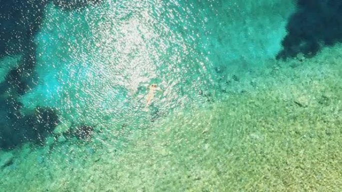 空中女人在亚得里亚海的绿松石水中放松