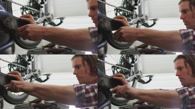 专注的高加索人在车库里用工具修理自行车