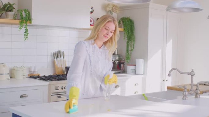 女人在家做家务戴着橡胶手套用喷雾和布清洁厨房柜台