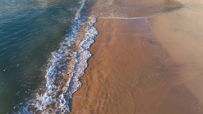 海浪在白色沙滩上破裂，绿松石翡翠色的水