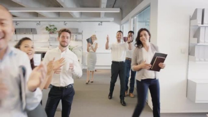 4k视频片段，一群不同的商人在办公室为同事鼓掌