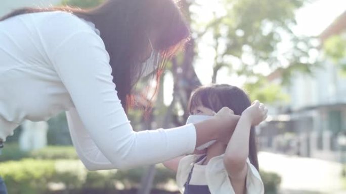 亚洲母亲为女儿戴上医用口罩