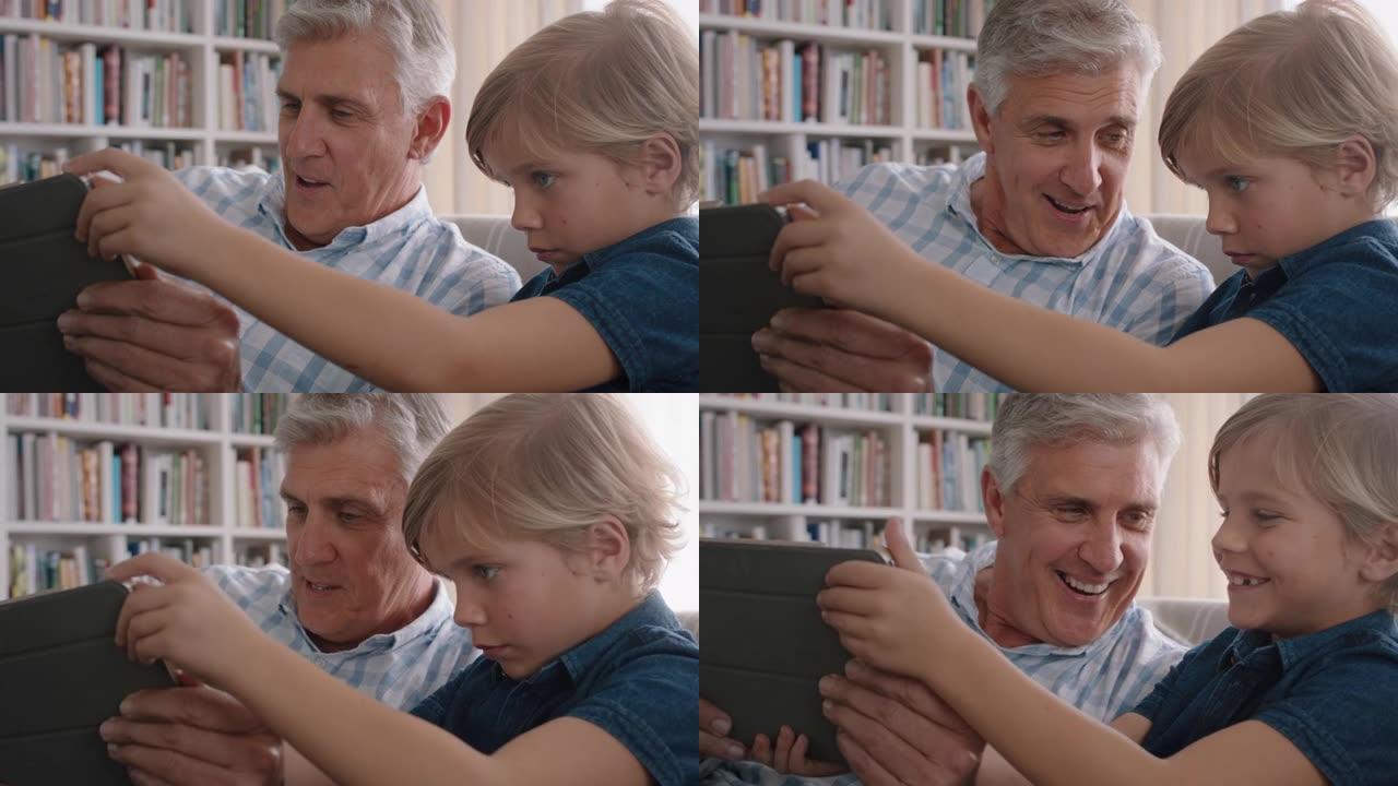 爷爷展示小男孩如何使用平板电脑教学好奇孙子现代科技智能儿童学习移动设备坐在沙发上爷爷4k