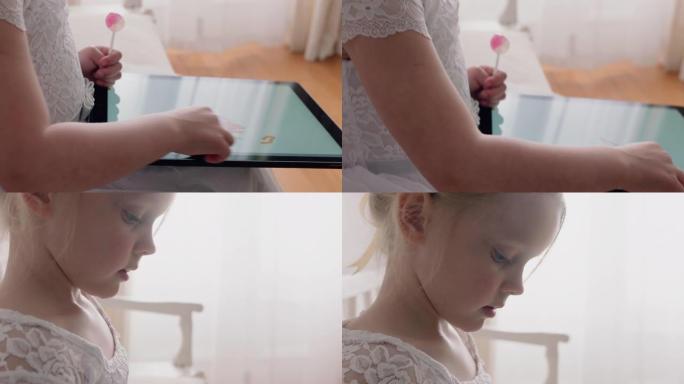 美丽的小女孩用平板电脑在触摸屏上画画享受创造力坐在长凳上，泰迪熊在家吃棒棒糖