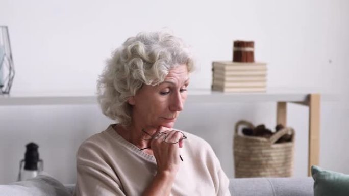 退休妇女因电脑过度劳累而感到眼睛紧张。