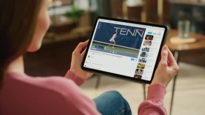 肩膀上的女人使用平板电脑观看女子网球锦标赛。参加比赛的专业体育运动员。模拟视频共享社交媒体平台上的实