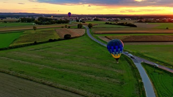 鸟瞰图热气球在日落时降落在农村地区
