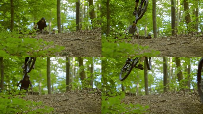 超级SLO MO MTB骑自行车的人在穿过森林的小径上跳过坡道