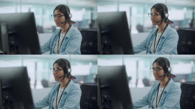 呼叫中心办公室: 友好的印度女性信息技术客户支持专家在电脑上工作的肖像。使用耳机通过在线视频电话与客