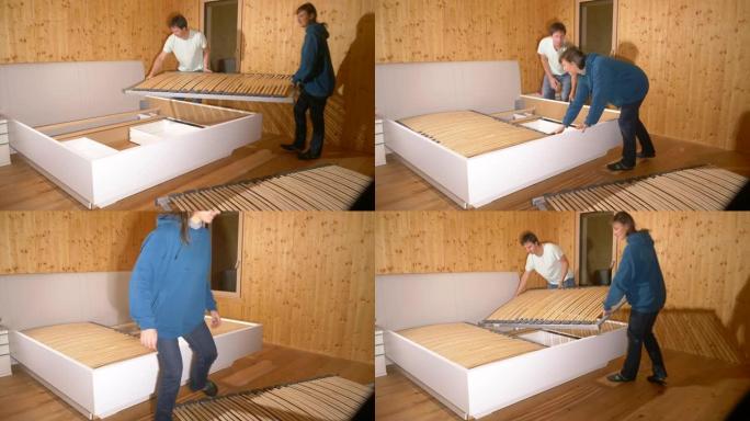 特写: 男人和女人将bunkie板安装在一张大床的床架上。