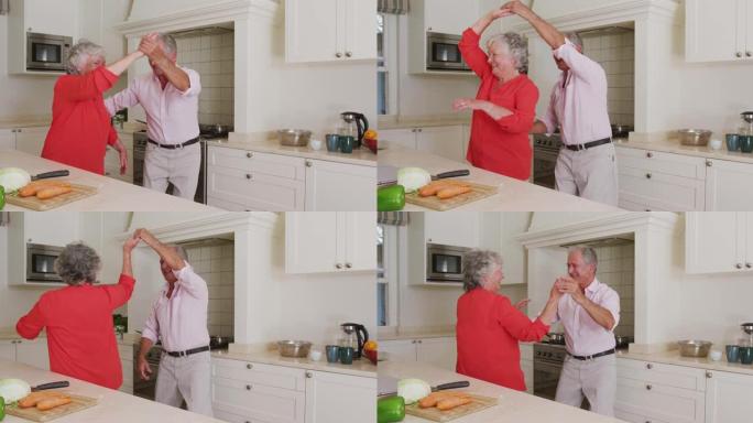 快乐的高加索高级夫妇在准备饭菜时在厨房跳舞很开心