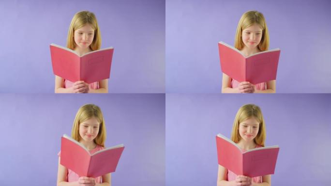 紫色背景下学习学校练习册的女孩的工作室镜头 -- 慢动作镜头
