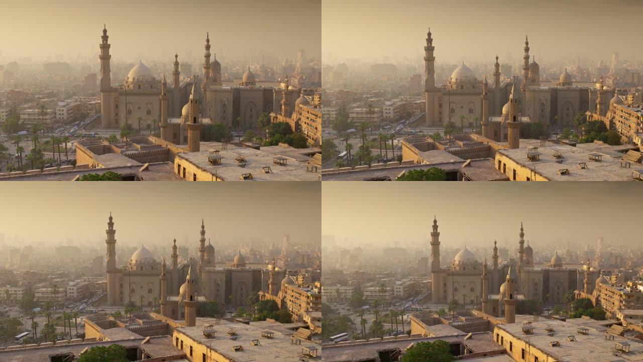 日落时，缩小埃及开罗苏丹哈桑清真寺。落日的轻雾中的开罗市