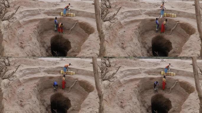 气候变化。干旱。水危机。由于持续干旱，非洲妇女从非常深的井中收集塑料容器中的水。肯尼亚