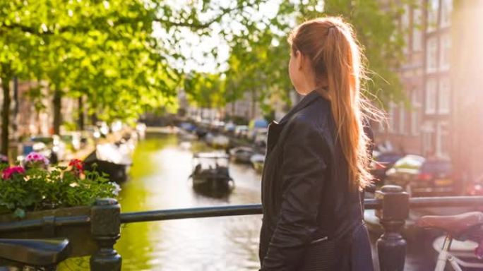 女人徒步探索阿姆斯特丹，沿着运河行走，骑自行车停在桥上，欣赏美景