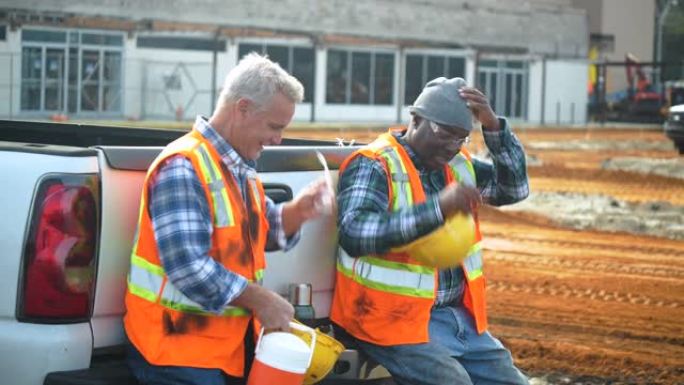 两名多种族建筑工人在喝咖啡休息