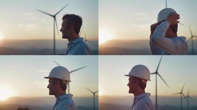 背景与风力涡轮机和美丽的日落: 肖像特写一个微笑的男工程师戴上安全帽，对他对更绿色，更可持续的未来的