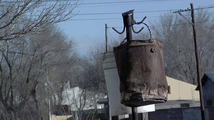 旧生锈的水桶挂在户外的电线上。特写。