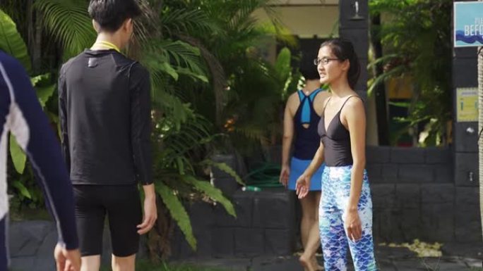 亚洲中国游泳教练带她所有的学生洗澡，然后进入游泳池并应用社交距离SOP