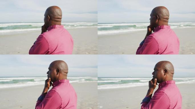 非裔美国男子在沙滩上漫步，看着大海