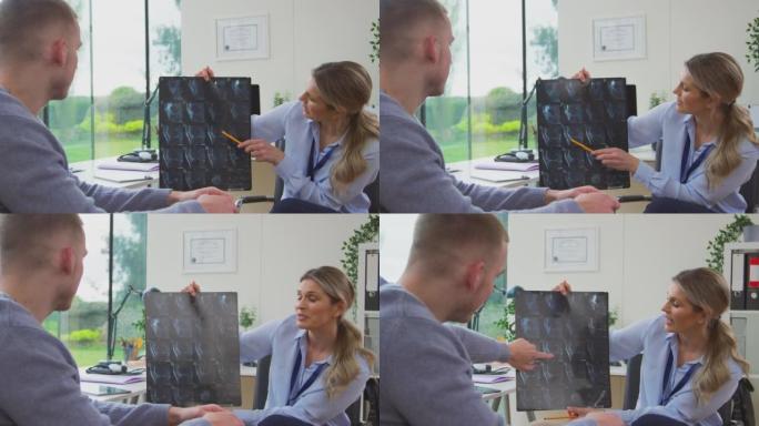 办公室里成熟的女医生与年轻的男性患者讨论ct扫描-慢动作拍摄