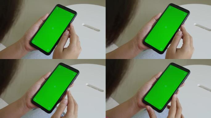 女人拿着色键绿屏智能手机看内容