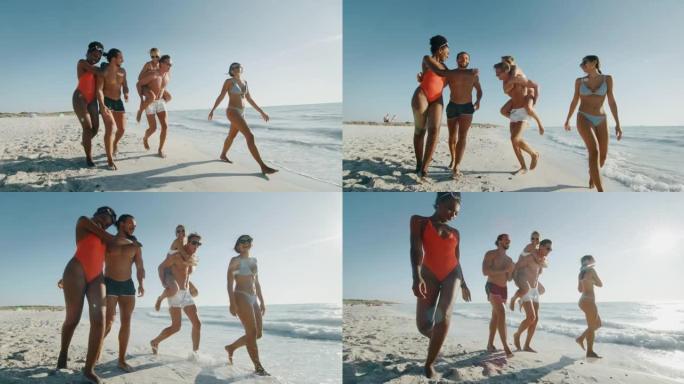 穿着泳衣的年轻多种族无忧无虑的朋友的慢动作在阳光明媚的日子里，在海边的海滩上玩得很开心，一起享受暑假
