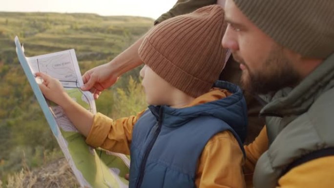 父母和孩子在远足时看着地图