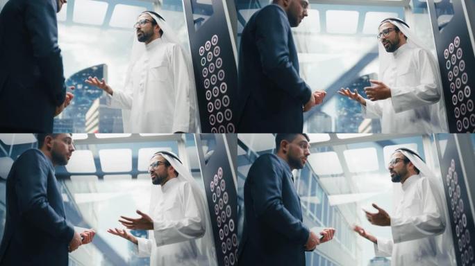 商人在现代商务中心乘坐玻璃电梯到办公室时与阿拉伯投资伙伴交谈。国际企业合伙人握手并达成协议。