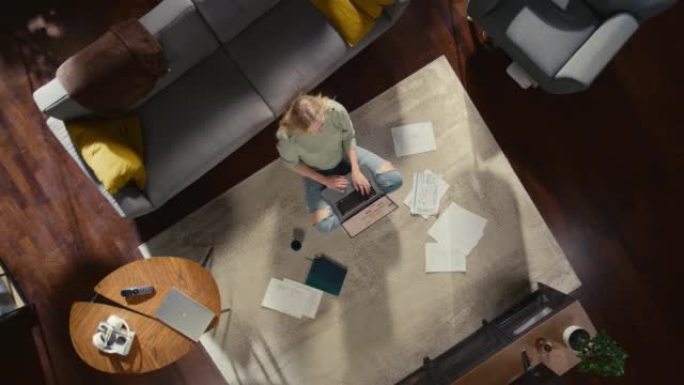 公寓: 年轻女子坐在客厅地板上，使用笔记本电脑。远程访问的女企业家在家远程工作。自由职业者做电子商务