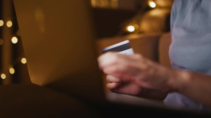 亚洲妇女在圣诞节在家中的笔记本电脑上在线购物，手持照片