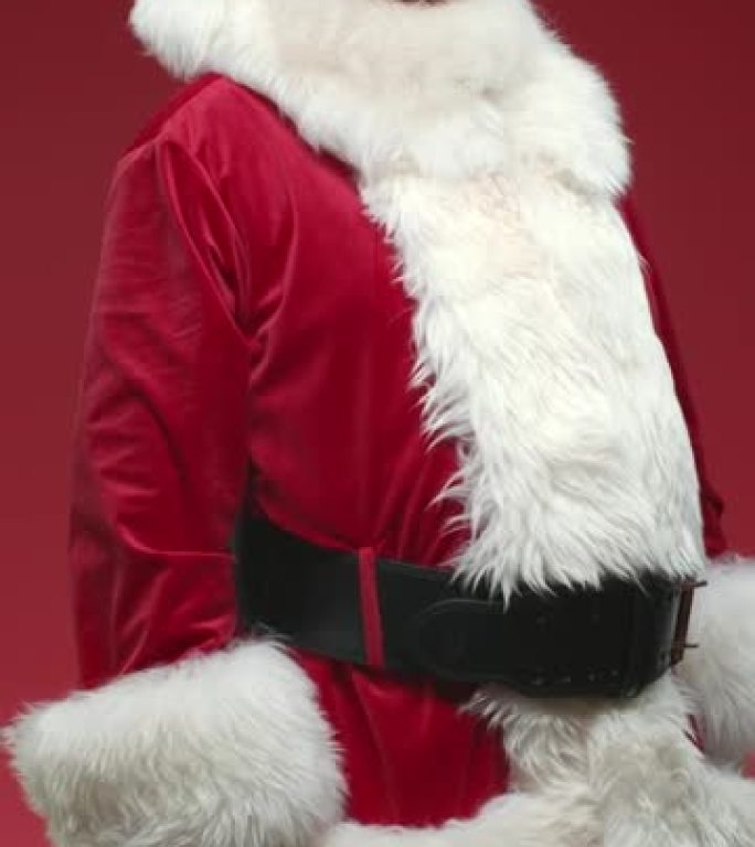 一个在红色背景上转身的圣诞老人，他的背部起初是在一帧中，然后他转身在相机中挥手