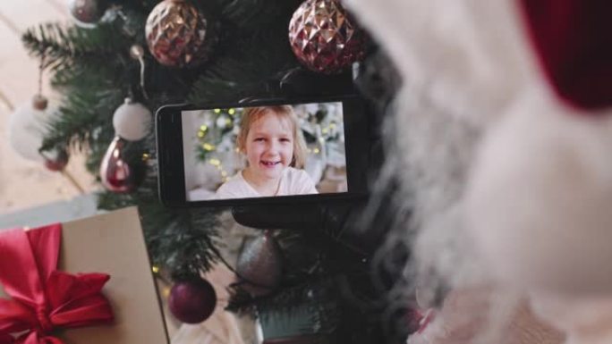 圣诞老人在智能手机上与小女孩视频聊天