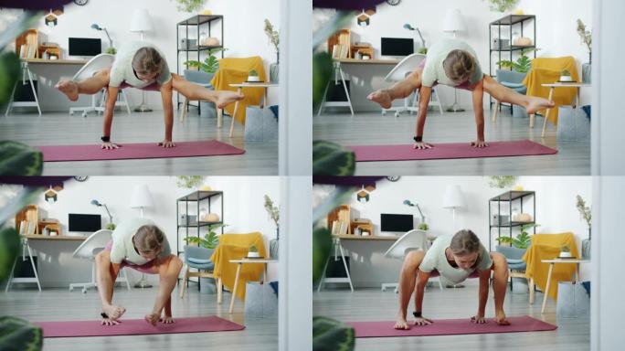 女瑜伽学生在家锻炼，在垫子上做手臂平衡体式