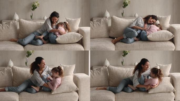 活泼开朗的女人和小女儿在沙发上玩耍