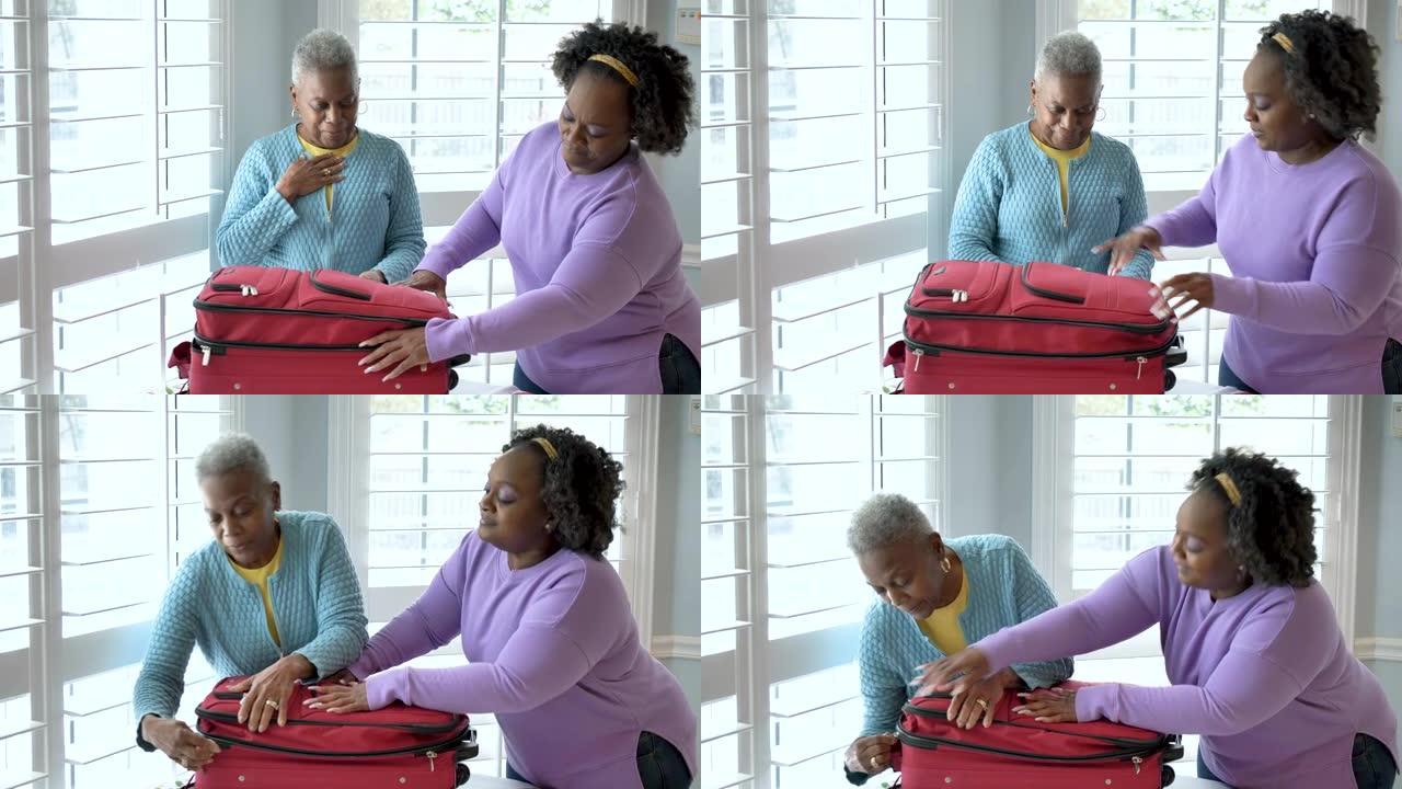 高级非裔美国妇女，女儿打包手提箱