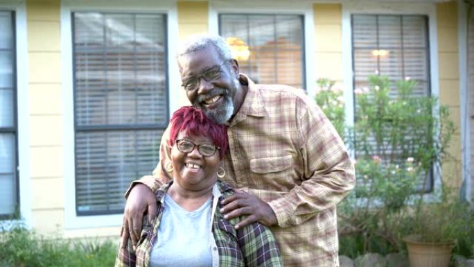 老年非裔美国夫妇在家门口拥抱