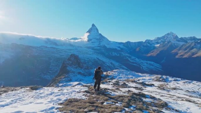 Man traveller在瑞士马特宏峰背景的山峰上拍照。