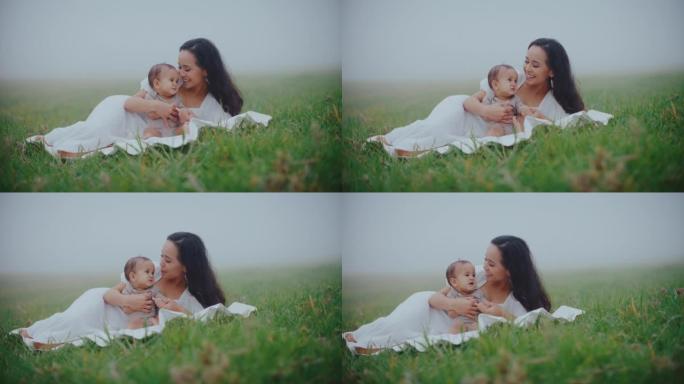 母亲和年幼的婴儿草丛草地小草亲情陪伴